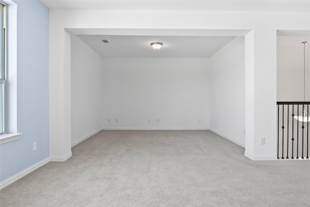 carpeted empty room with baseboards and visible vents