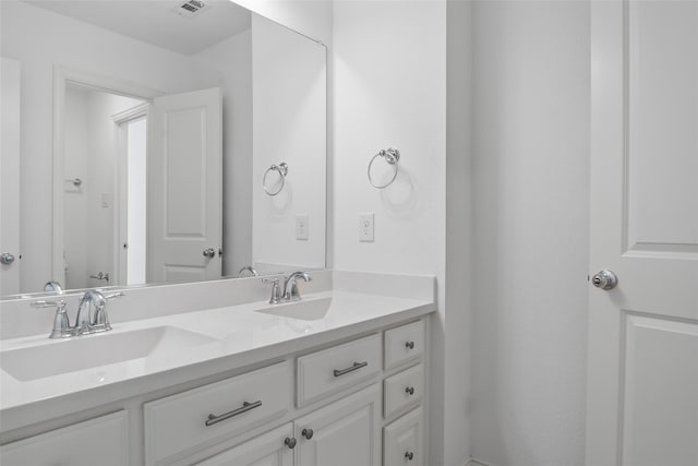 bathroom with double vanity, visible vents, and a sink