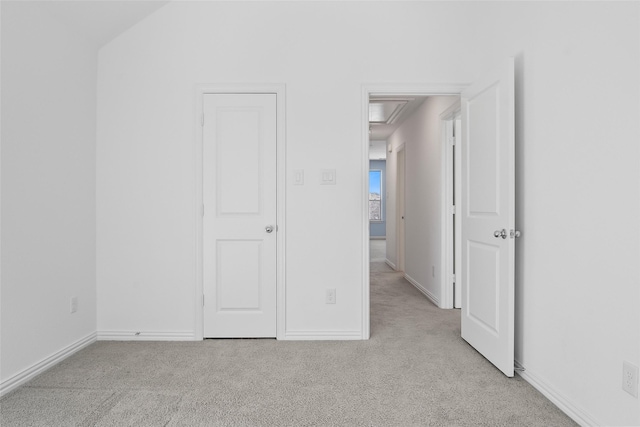 unfurnished bedroom featuring light carpet and baseboards