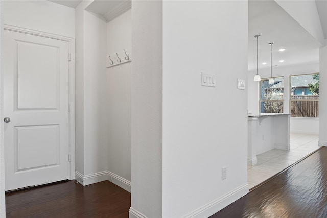 hall with baseboards and wood finished floors