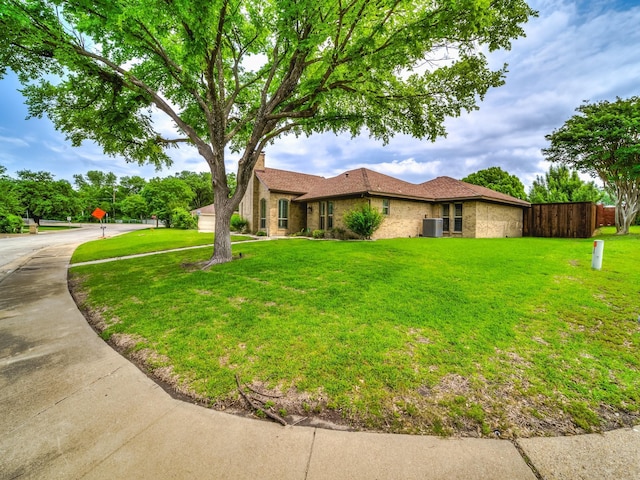 single story home featuring a front yard, fence, an attached garage, concrete driveway, and brick siding