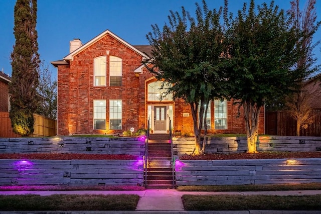 traditional home with fence, brick siding, and a chimney