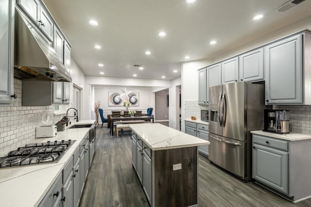 kitchen with visible vents, gray cabinetry, a center island, under cabinet range hood, and appliances with stainless steel finishes