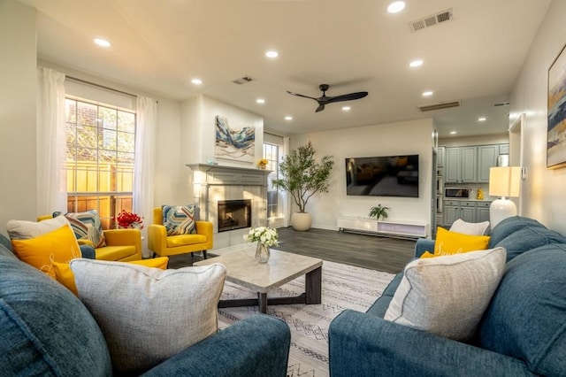 living area featuring recessed lighting, visible vents, wood finished floors, and a fireplace