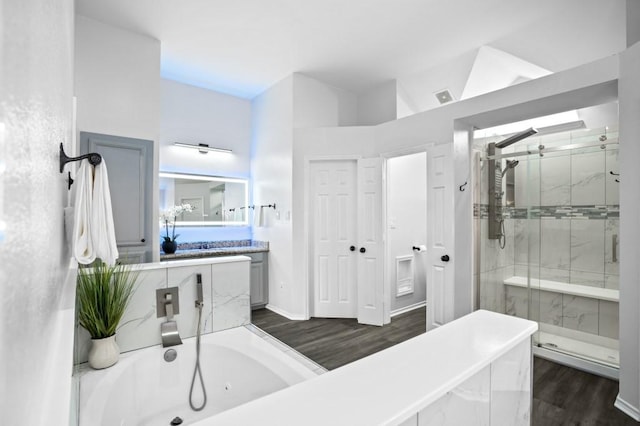 full bath featuring visible vents, a stall shower, wood finished floors, a tub with jets, and vanity