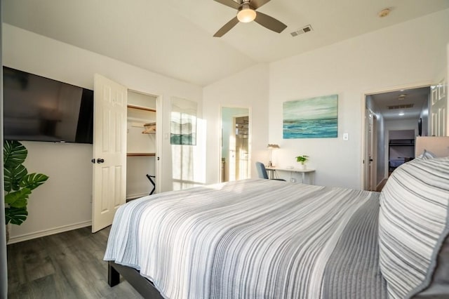 bedroom featuring a spacious closet, visible vents, lofted ceiling, wood finished floors, and a ceiling fan