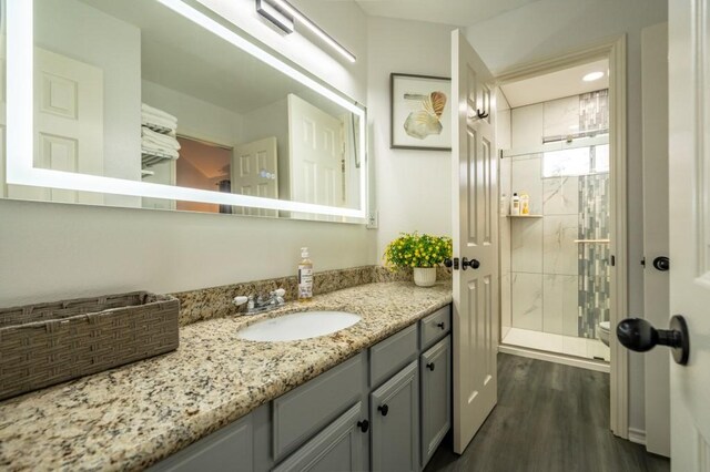 bathroom with vanity, wood finished floors, and a stall shower