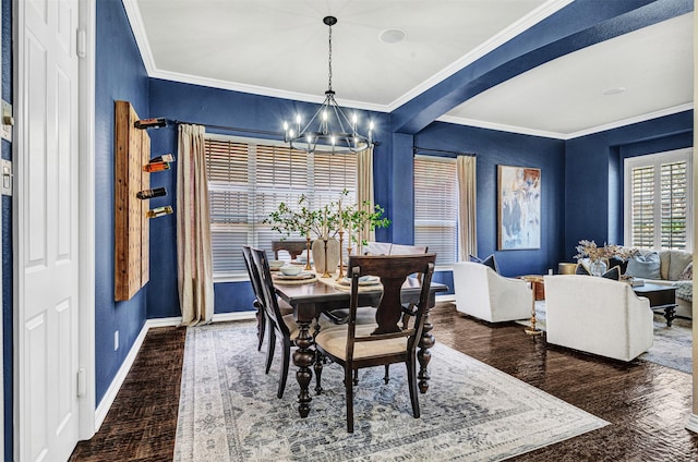 dining space with baseboards, crown molding, an inviting chandelier, and wood finished floors