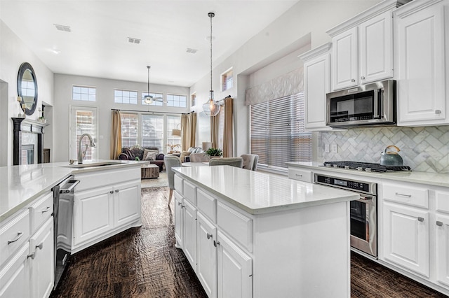 kitchen with backsplash, visible vents, a kitchen island, and appliances with stainless steel finishes