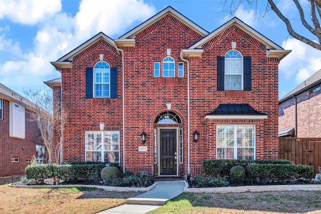 traditional home with brick siding and fence