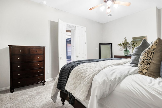 bedroom featuring a ceiling fan, light colored carpet, visible vents, and baseboards