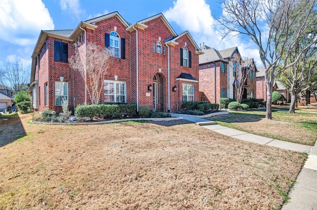 traditional-style house with brick siding and a front lawn