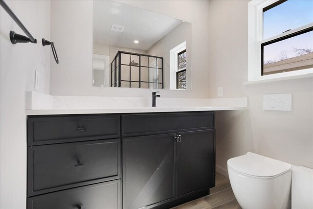 full bathroom with vanity, wood finished floors, visible vents, a stall shower, and toilet