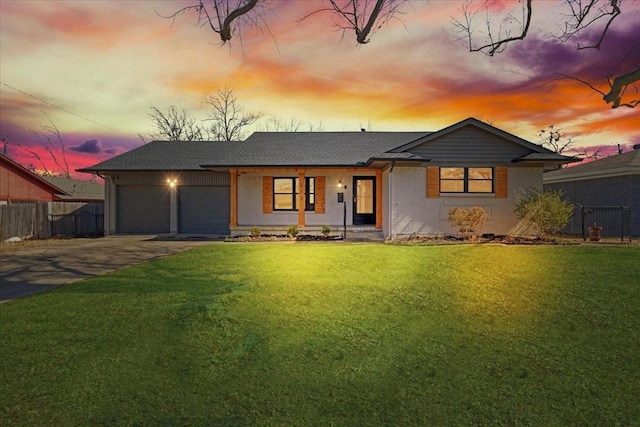 view of front of property with driveway, a front lawn, a garage, and fence