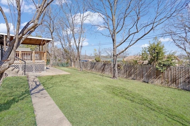 view of yard with a wooden deck and a fenced backyard