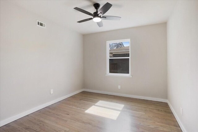 empty room with light wood-type flooring, visible vents, baseboards, and a ceiling fan