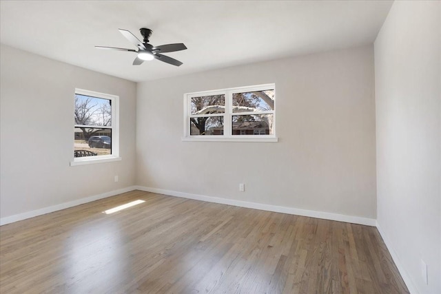 unfurnished room featuring a ceiling fan, wood finished floors, and baseboards