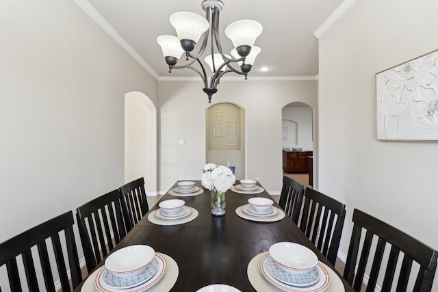 dining room featuring baseboards, arched walkways, an inviting chandelier, and crown molding