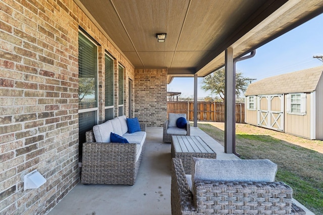 view of patio / terrace with outdoor lounge area, an outdoor structure, a storage unit, and fence