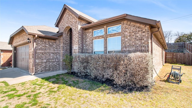 view of front of home with a front yard, a garage, fence, and brick siding