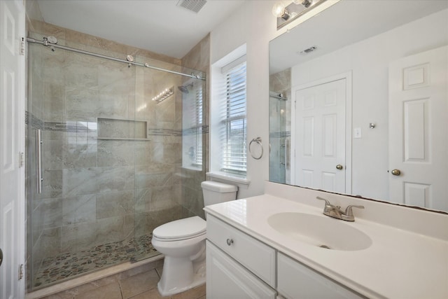 bathroom featuring visible vents, toilet, a stall shower, and vanity