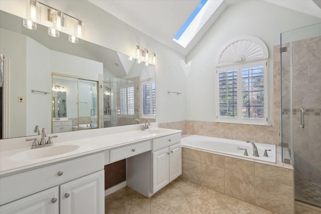 bathroom featuring lofted ceiling with skylight, a shower stall, and a sink