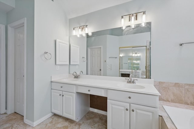 full bathroom featuring double vanity, baseboards, a garden tub, and a sink