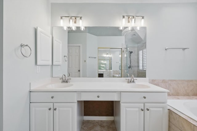 bathroom featuring a shower stall, a garden tub, double vanity, and a sink