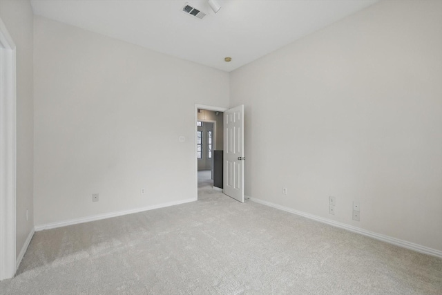 unfurnished room featuring visible vents, baseboards, and light colored carpet