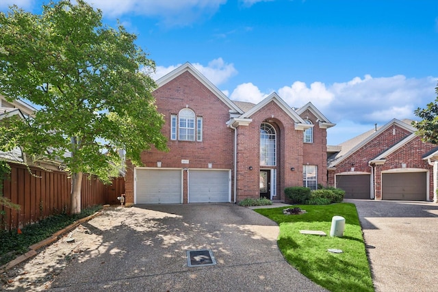 traditional-style home with brick siding, concrete driveway, a garage, and fence