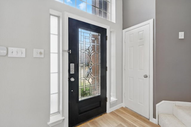 foyer entrance featuring baseboards and light wood finished floors