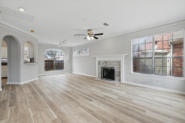 unfurnished living room featuring a ceiling fan, light wood-style flooring, a fireplace, and visible vents