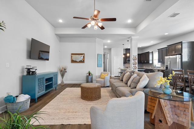 living area featuring a ceiling fan, dark wood-style floors, visible vents, baseboards, and recessed lighting