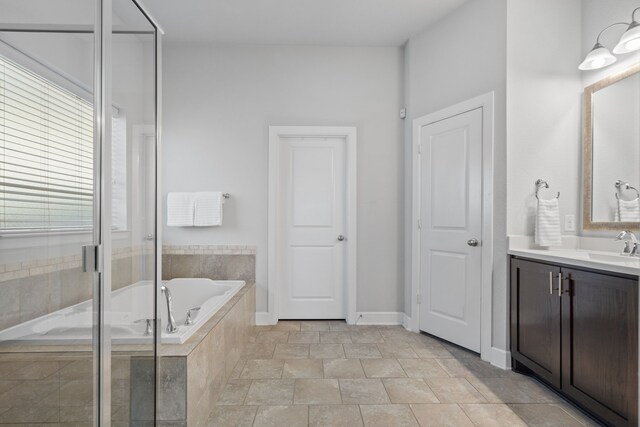 full bath with baseboards, a stall shower, vanity, and a garden tub