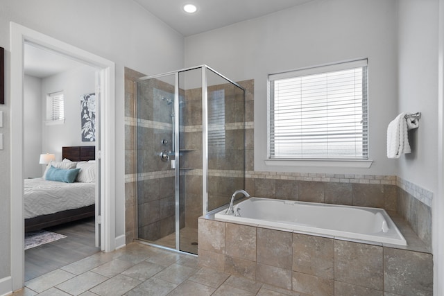 bathroom with ensuite bath, a shower stall, and a garden tub