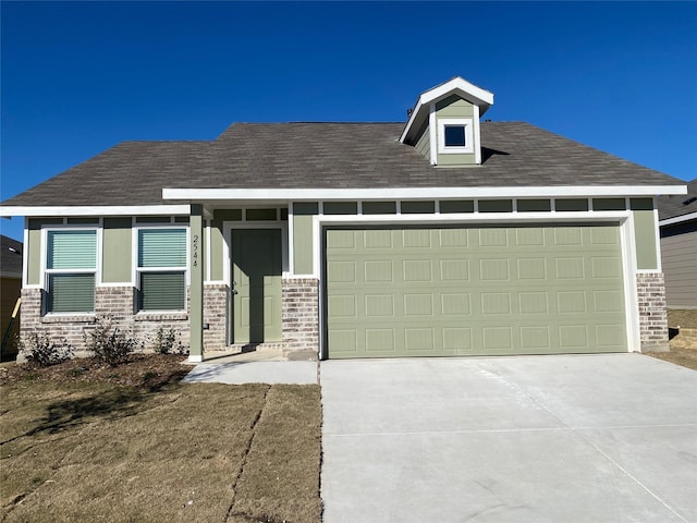 view of front of home featuring an attached garage, concrete driveway, and roof with shingles