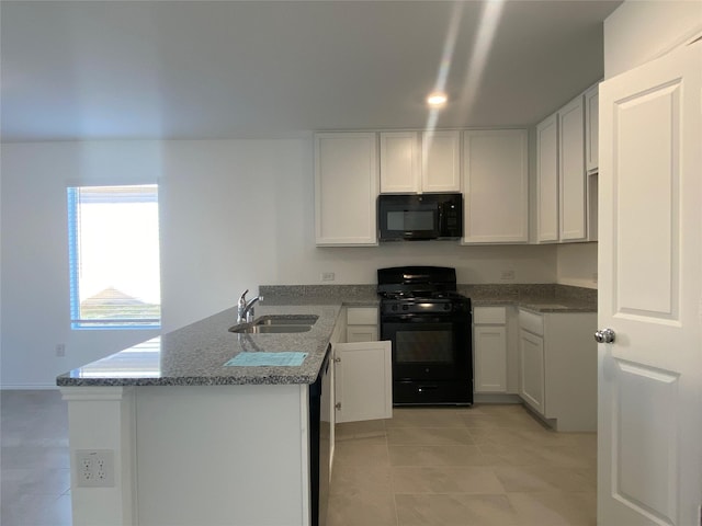 kitchen with white cabinetry, a peninsula, black appliances, and a sink