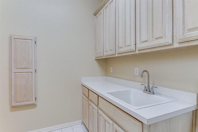 laundry room with light tile patterned floors, baseboards, and a sink