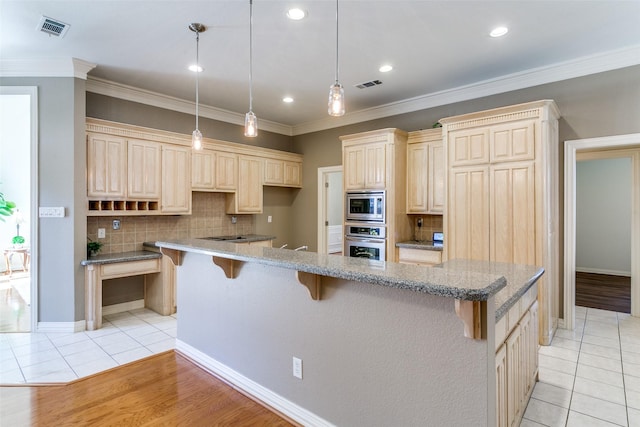 kitchen featuring a kitchen breakfast bar, light tile patterned flooring, visible vents, and appliances with stainless steel finishes