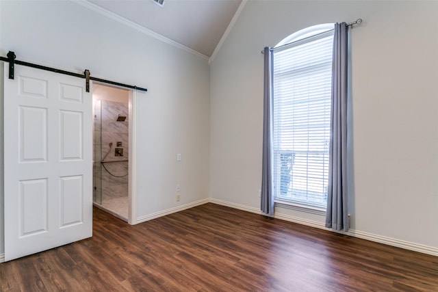 unfurnished room with baseboards, lofted ceiling, a barn door, ornamental molding, and dark wood-style floors