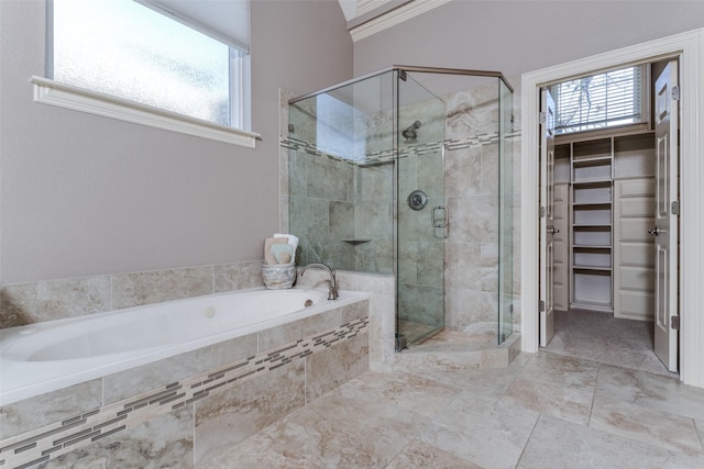 bathroom with a shower stall, crown molding, a walk in closet, and a garden tub