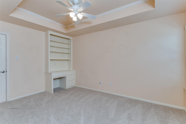 unfurnished living room with baseboards, a raised ceiling, light carpet, and crown molding