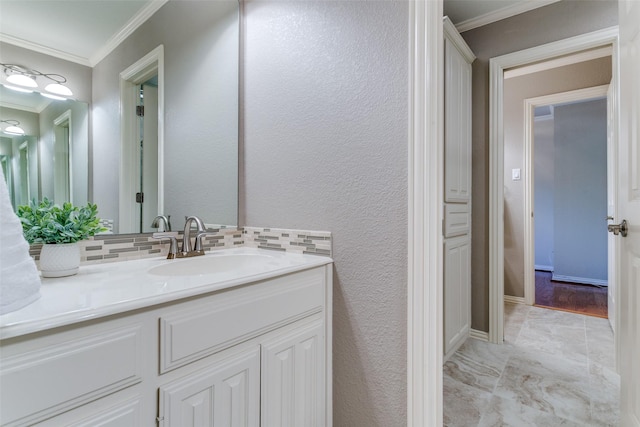 bathroom featuring vanity, backsplash, crown molding, and a textured wall