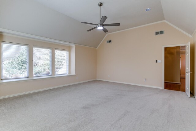 unfurnished room with visible vents, ornamental molding, baseboards, light colored carpet, and vaulted ceiling