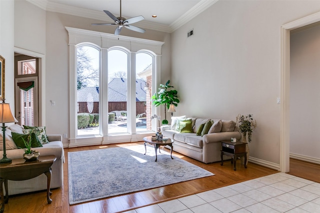 living room featuring visible vents, ornamental molding, a ceiling fan, and wood finished floors