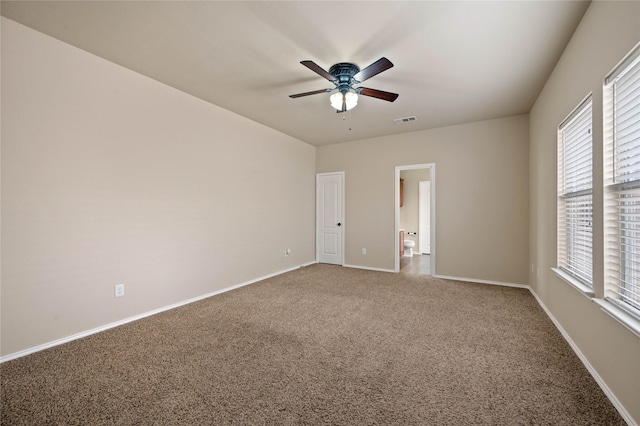 carpeted empty room featuring a ceiling fan, baseboards, and visible vents