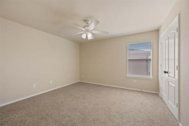 empty room featuring baseboards, ceiling fan, and carpet flooring