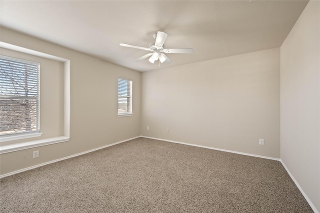 carpeted empty room featuring baseboards and ceiling fan