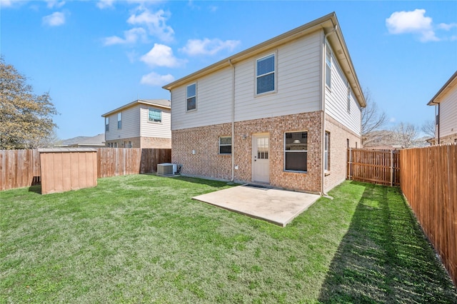 back of house featuring a patio, brick siding, a fenced backyard, and a lawn