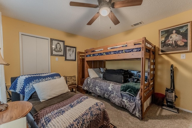 carpeted bedroom featuring visible vents, baseboards, a textured ceiling, and a ceiling fan